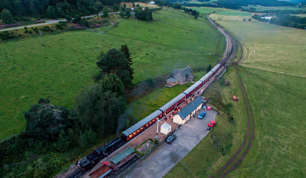 Drone view of Broomhill/Glenbogle station with steam Locomotive 46512 locomotive preparing to depart for Aviemore